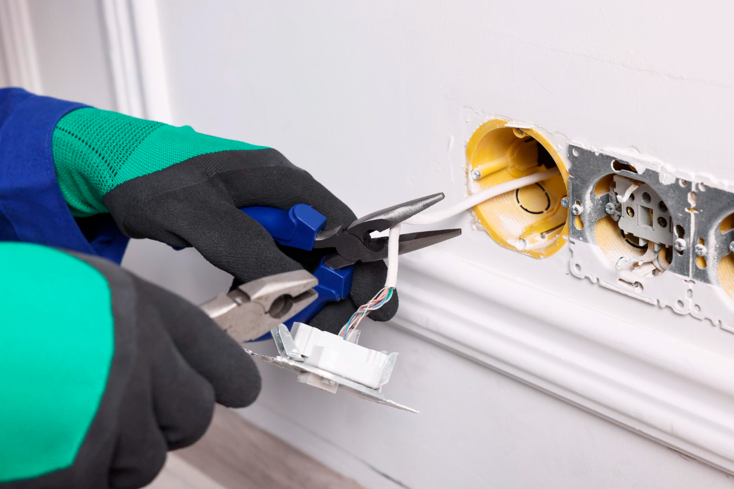 Électricien réparant une prise murale lors d’un dépannage